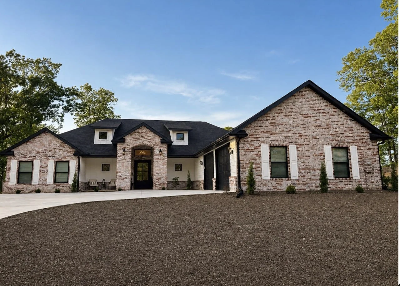 Modern single-story brick house with black roof, white shutters, and attached garage